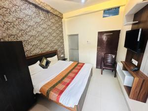 a hotel room with a bed and a television at Hotel Lake View in Varanasi +6 photos