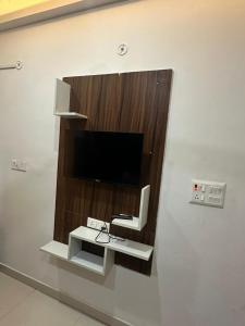 a tv on a wall with a chair in a room at Hotel Lake View in Varanasi