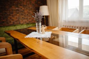a wooden table with a vase of flowers on it at Pstrug House in Yasinya