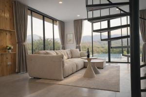 a living room with a white couch and a table at Solitude Villas in Ban Chang Talut