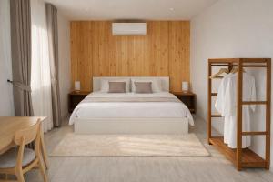 a bedroom with a white bed and a wooden wall at Solitude Villas in Ban Chang Talut