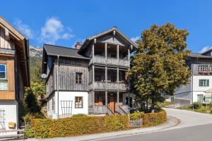 an old house in the mountains with a tree at Haus Grundlseeblick in Bräuhof