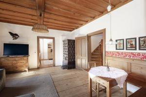 a living room with a table and a tv at Haus Grundlseeblick in Bräuhof