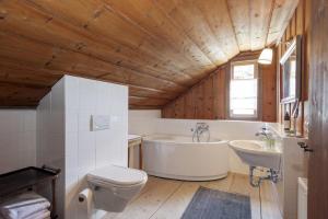 a bathroom with a tub and a toilet and a sink at Haus Grundlseeblick in Bräuhof +24 photos