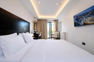 a bedroom with a large white bed and a desk at Areos in Athens