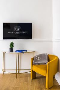 a yellow chair sitting next to a table and a table and a bench at Themis Toledo - Private Spa Apartment in Naples