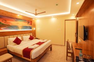 a hotel room with a bed and a television at Le Kumar Residency in Pondicherry +31 photos