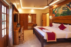 a bedroom with a large bed and a desk in it at Le Kumar Residency in Pondicherry