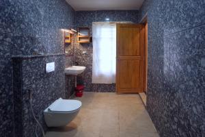 a bathroom with a toilet and a sink at Le Kumar Residency in Pondicherry
