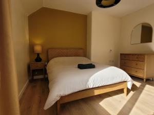 a bedroom with a bed with a black bag on it at Riverside Home Kinlochleven in Kinlochleven