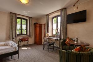 a hotel room with a bed a desk and a tv at AKZENT Hotel Franziskaner in Dettelbach