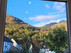 a view of a mountain from a window at Riverside Home Kinlochleven in Kinlochleven