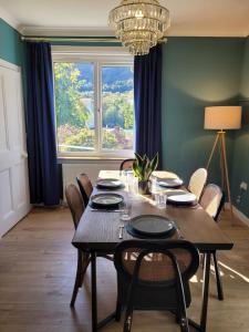 a dining room with a table and chairs and a window at Riverside Home Kinlochleven in Kinlochleven