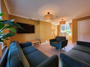 a living room with a couch and a tv at Riverside Home Kinlochleven in Kinlochleven