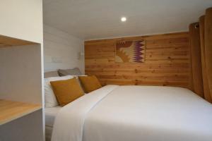 a bedroom with a white bed and a wooden wall at Tiny Twins - TinyHouse 6 personnes à Malmedy by LaConciergerie in Malmedy