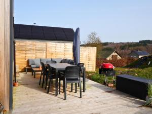 a patio with a table and chairs and an umbrella at Tiny Twins - TinyHouse 6 personnes à Malmedy by LaConciergerie in Malmedy