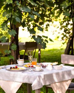 Ein Tisch mit Speisen und Getränken unter einem Baum in der Unterkunft Badia Giulia Prestigious Historical B&B, Camaiore - Adults Only - No Pets in Camaiore