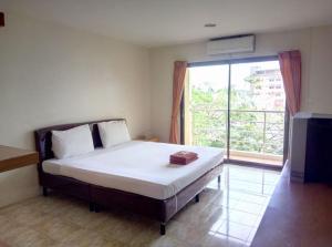 a bedroom with a bed with a large window at Pearl Place Hotel in Hat Yai