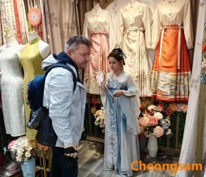 a man and a woman standing in front of a display of dresses at Shan Tao Inn -山韬客栈- Good location-English reception-Ticket service-Tourism planing-coffee-Laundry-kung fu Tea-Drone gopro rental in Zhangjiajie