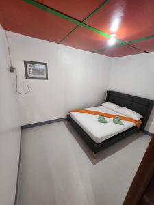 a small bedroom with a bed in a room at Nirvana bamboo houses & dive centre in Moalboal