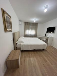 a bedroom with a bed and a table and a tv at Grelios stanze preziose in Guardiagrele