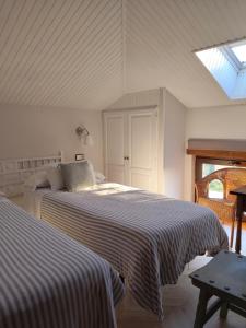 a bedroom with two beds and a skylight at Apartamentos Los Hidalgos in Santillana del Mar