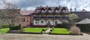 a large white house with a black roof at Dolina Wilema in Bolesławów