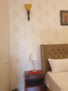 a bedroom with a bed and a lamp on a table at سمح الضيافة in Ţubarjal