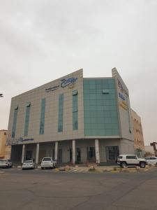 a large building with cars parked in a parking lot at سمح الضيافة in Ţubarjal