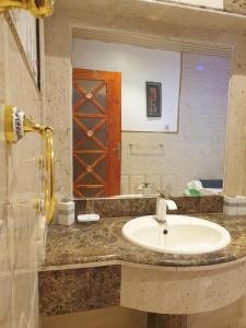 a bathroom with a sink and a mirror at سمح الضيافة in Ţubarjal