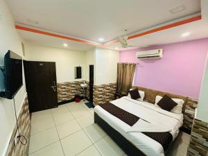 a bedroom with a bed and a pink wall at Hotel Srinivas in Jodhpur