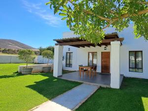 a white house with a table in a yard at Meerendal Boutique Hotel in Durbanville