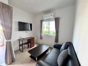a living room with a couch and a table at Swiss Resort in Ban Phe