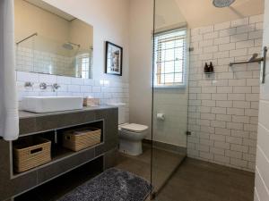 a bathroom with a sink and a toilet and a shower at Meerendal Boutique Hotel in Durbanville