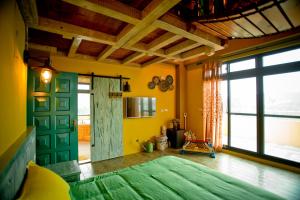 a bedroom with a green bed and a large window at Kaho Homestay II in Hualien City