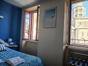 a bedroom with a bed and a window at Hôtel restaurant Notre Dame in Orcival
