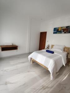 a white bedroom with a bed in a room at Villa Bagus in Lovina