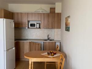 a small kitchen with a table and a white refrigerator at Изгрев-Бяла in Byala
