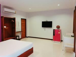 a bedroom with a bed and a red refrigerator at Graphic House @ Chiang Rai in Chiang Rai