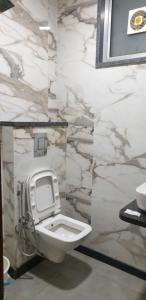 a bathroom with a white toilet and a marble wall at Hotel Star Paradise in New Delhi +20 photos