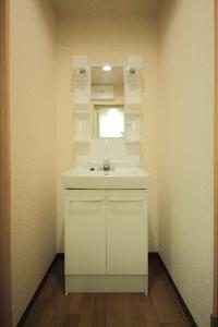 a bathroom with a sink and a mirror at Guest House Keage in Kyoto