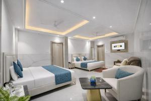 a bedroom with two beds and a couch and a table at Hotel International Inn - Near Delhi Airport in New Delhi