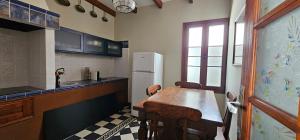 a kitchen with a wooden table and a refrigerator at La Barbacoa in Dos Pinos