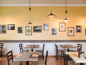 a dining room with tables and photos on the wall at The Courtyard Retreat in Brunate