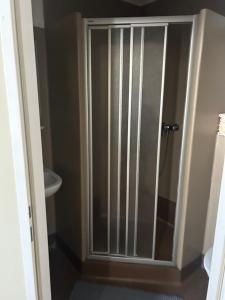 a shower with a glass door in a bathroom at K+T Boardinghouse in Vienna