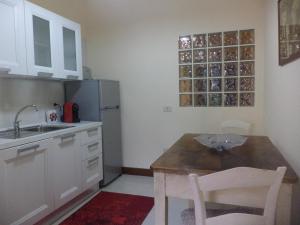 cocina con mesa, fregadero y nevera en Residenza Pietrafosca, en Monsummano