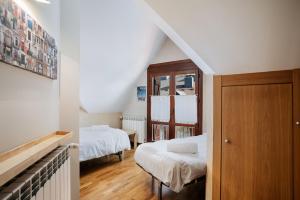 a attic room with two beds and a staircase at Gaudioso by Cardi Suites in Sallent de Gállego +26 photos