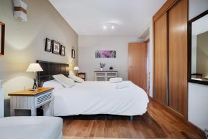a bedroom with two beds and a table and a desk at Gaudioso by Cardi Suites in Sallent de Gállego