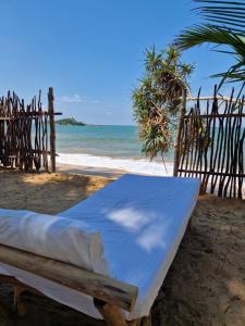 a bed on the beach with the ocean in the background at CocoVilla Boutique Resort in Beruwala