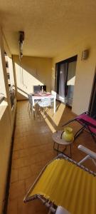 a living room with tables and chairs in a building at A 2 pas du port, du centre, du marché provençal, des plages quartier calme in Sanary-sur-Mer